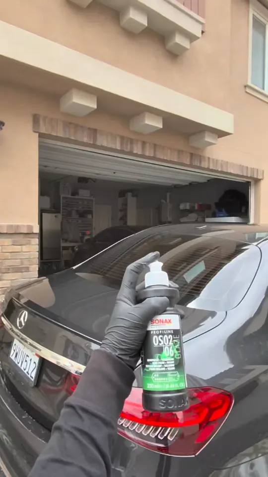Preparing polish at the rear of a Mercedes-Benz sedan