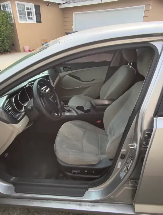 Front seats of a sedan with light cloth upholstery before the interior reset