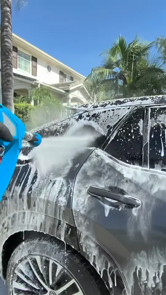 Rinsing foam off the side of a gray Lexus SUV