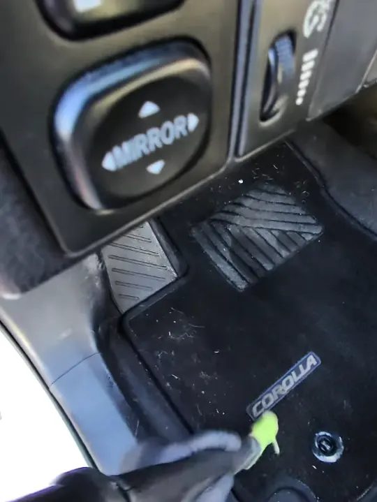 Brushing a front floor mat inside a sedan