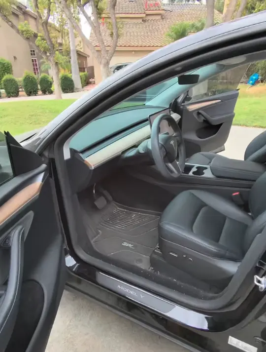 Tesla Model Y front cabin before cleaning, debris on the floor mats