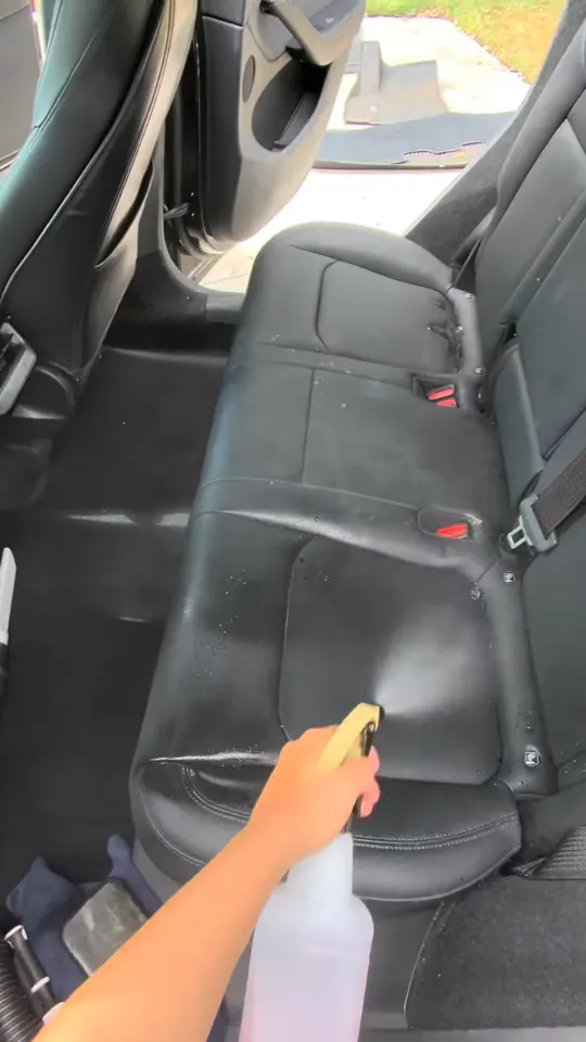Spraying and cleaning the rear leather seats of a Tesla